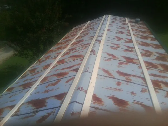 Rusted metal roof panels with new wood purlins before replacement — Storm Damage Roof Repair in Leonard by Roofing Brothers